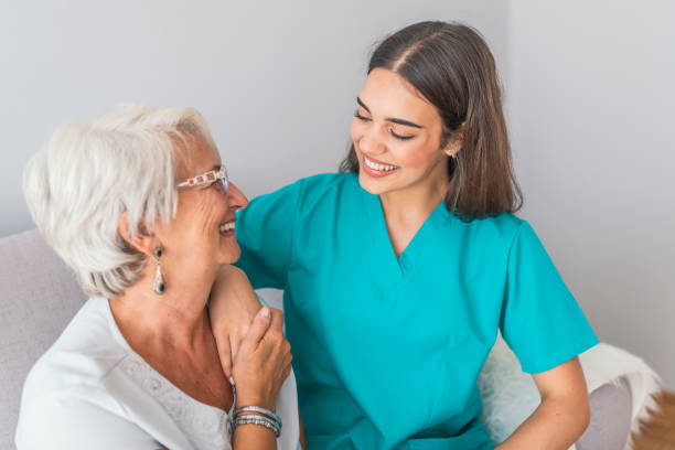 Nurse Talking With Senior Woman Sitting In Chair On Home Visit Nurse Talking With Senior Woman Sitting In Chair On Home Visit. Female Community Nurse Visits Senior Woman At Home. Female Support Worker Visits Senior Woman female nurse stock pictures, royalty-free photos & images