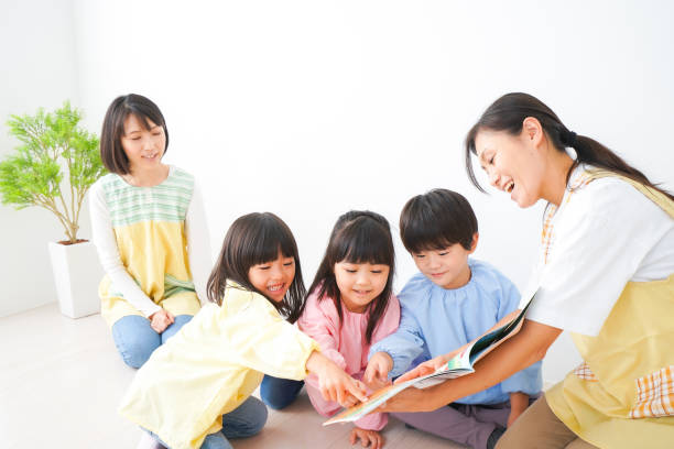 Nursery teacher and children reading a picture book Nursery teacher and children reading a picture book child korea little girls korean ethnicity stock pictures, royalty-free photos & images