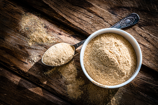 Nutritional supplement: Maca root powder in a white bowl shot from above on rustic wooden table. High resolution 42Mp studio digital capture taken with Sony A7rII and Sony FE 90mm f2.8 macro G OSS lens