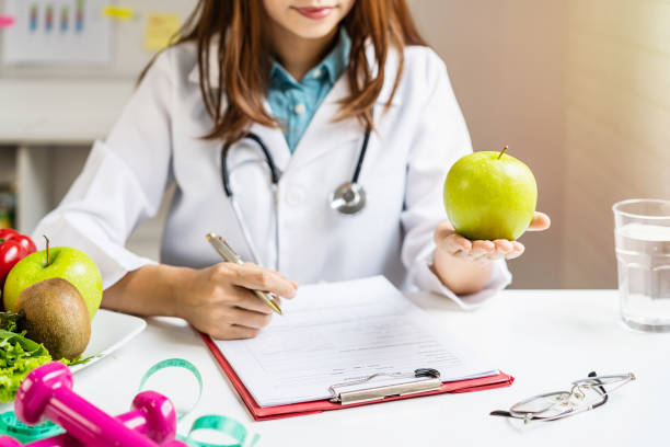 Nutritionist giving consultation to patient with healthy fruit and vegetable, Right nutrition and diet concept Nutritionist giving consultation to patient with healthy fruit and vegetable, Right nutrition and diet concept nutritionist stock pictures, royalty-free photos & images