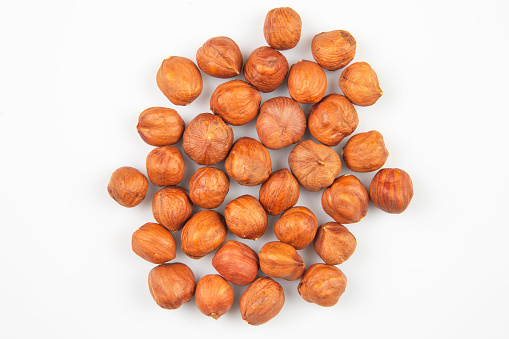 Different nuts in a wooden bowl on a white background. Vitamin wholesome food.