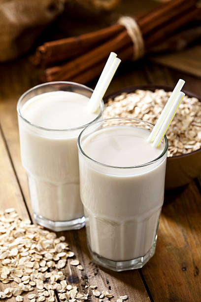 Oat Smoothie Two Oat Smoothies on Wooden Table  oats milk stock pictures, royalty-free photos & images