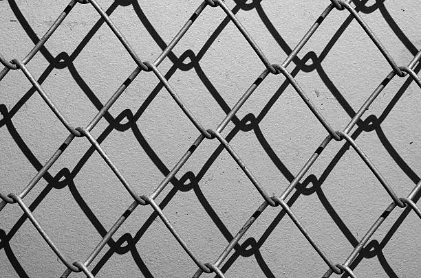 Obsolete gray grunge concrete closed with chain link fence Obsolete gray grunge concrete closed with chain link fence and shadows linkage effect stock pictures, royalty-free photos & images