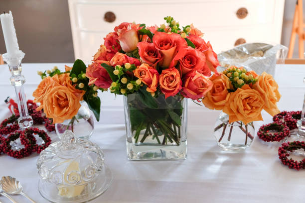 Occasions - Beautiful Floral Centerpiece on Table Gorgeous floral arrangements placed in 3 vases in the center of dining table on top of white table cloth. centerpiece stock pictures, royalty-free photos & images
