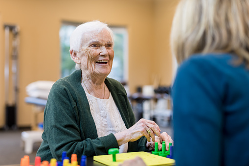 Occupational Therapist Works With An Elderly Woman Stock Photo