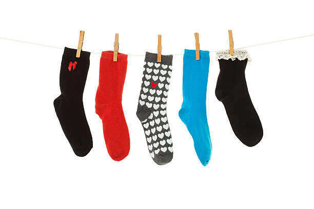 Odd Socks Odd socks whose mates have been lost, hanging on a clothesline.  Shot on white background. sock stock pictures, royalty-free photos & images
