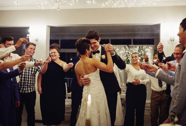 Of all the dances they've danced, this is their favourite Shot of a young couple dancing at their wedding reception while surrounded by their friends and sparklers wedding reception stock pictures, royalty-free photos & images