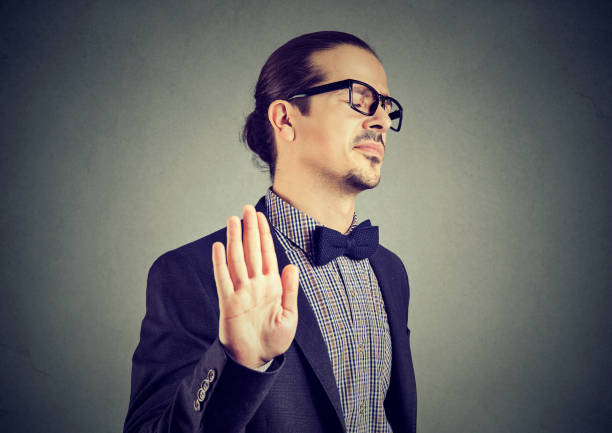 Offended man giving stopping gesture Young elegant man in eyeglasses stopping with hand while looking annoyed and insulted. snob stock pictures, royalty-free photos & images