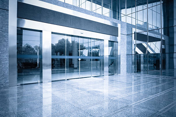 office building entrance and automatic glass door modern office building gate entrance and automatic glass door with blue tone automatic stock pictures, royalty-free photos & images