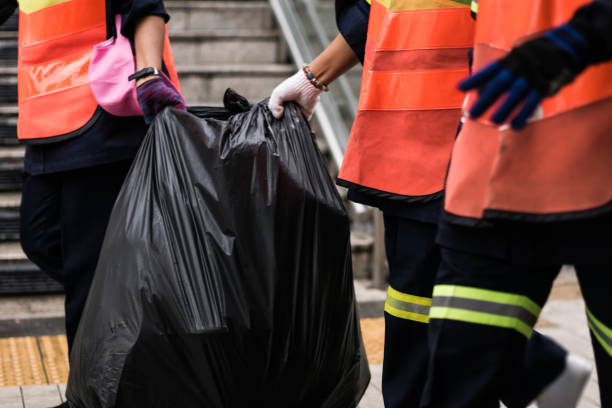 funcionários, lixo estão ajudando uns aos outros a transportar sacos de lixo para a loja. - gari - fotografias e filmes do acervo