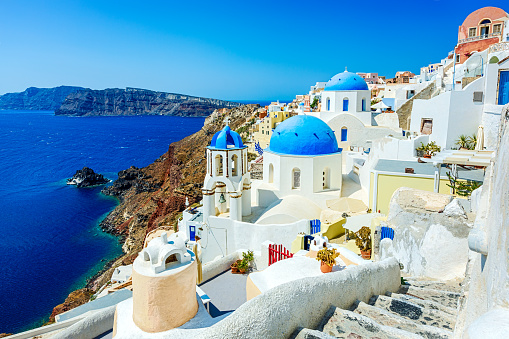 Idyllic village Oia (Ia) on Santorini island, Greece with famous church with blue domes. Click for more images: