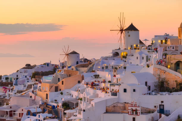 Oia village, Santorini, Greece. View of traditional houses in Santorini. Small narrow streets and rooftops of houses, churches and hotels. Landscape during sunset. Travel and vacation photography. stock photo