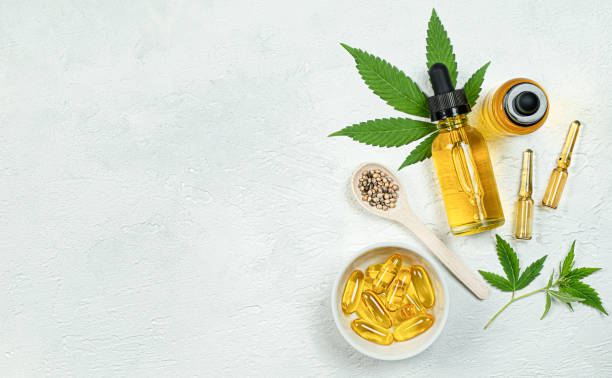 oil, capsules, ampoules, seeds and fresh cannabis leaves cbd oil, capsules, ampoules, seeds and fresh cannabis leaves on gray concrete background top view cbd oil stock pictures, royalty-free photos & images