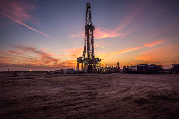 Oil drilling platform at sunset stock photo