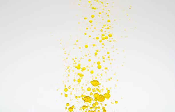 Oil drops isolated. Golden liquid drops of oil in water on a white background. Food or cosmetics component. stock photo