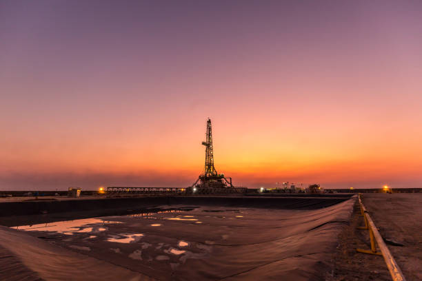 Oil fracking rig at sunset stock photo