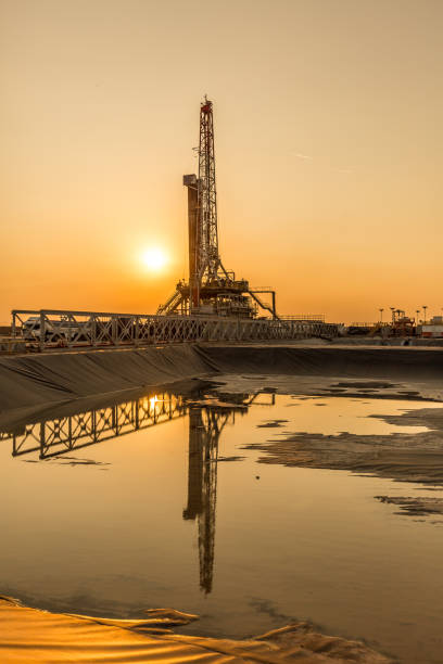 Oil fracking rig at sunset stock photo