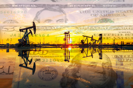 Dollars, yuan and oil pumps,Petroleum, petrodollar and crude oil concept, Oil pump on background of US dollar and RMB,