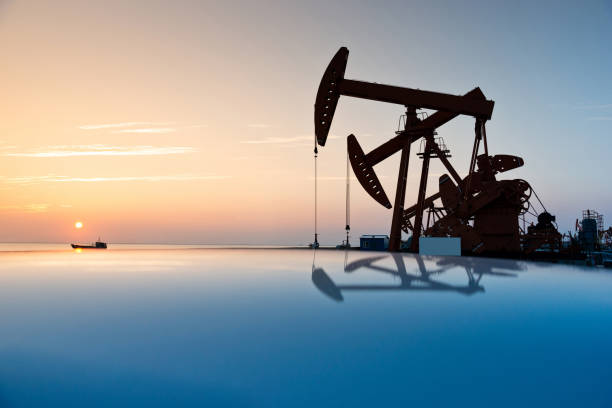 Oil pumps working in oil field at sunset stock photo