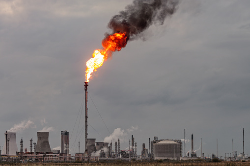 Environmental damage: A large flame and dark smoke rising from a flare stack at Grangemouth oil refinery and petrochemical plant in Scotland.