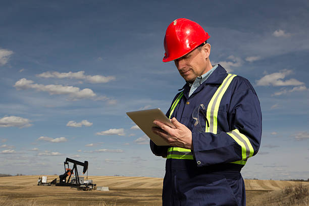 Oil Worker An image from the oil industry of an oil worker using a tablet PC. geologist stock pictures, royalty-free photos & images