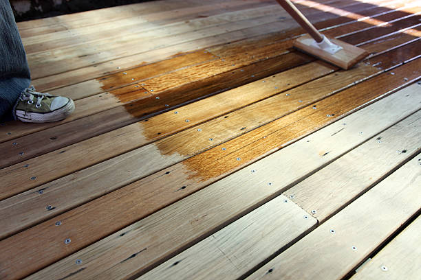 Oiling the deck Oiling a recycled timber outdoors deck for protection against the elements deck stock pictures, royalty-free photos & images