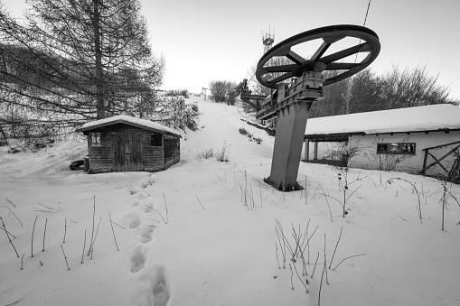Old abandoned skilift, in the hilly area of Oltrepo Pavese (Northern Italy, Lombardy Region), covered by snow.