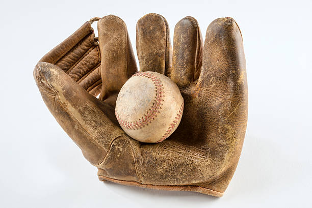 старый бейсбол перчатки и мяч - background of kids playing baseball стоковы...