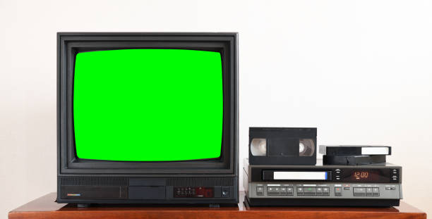 Old black vintage TV with green screen to add new images to the screen, VCR on wallpaper background. Old black vintage TV with green screen to add new images to the screen, VCR on wallpaper background. 90s television set stock pictures, royalty-free photos & images