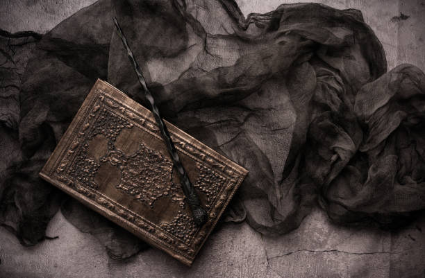 Old book with spells and magic wand on gray background with witch rag. Copy space for text Old book with spells and magic wand on gray background with witch rag. Copy space for text wizard stock pictures, royalty-free photos & images