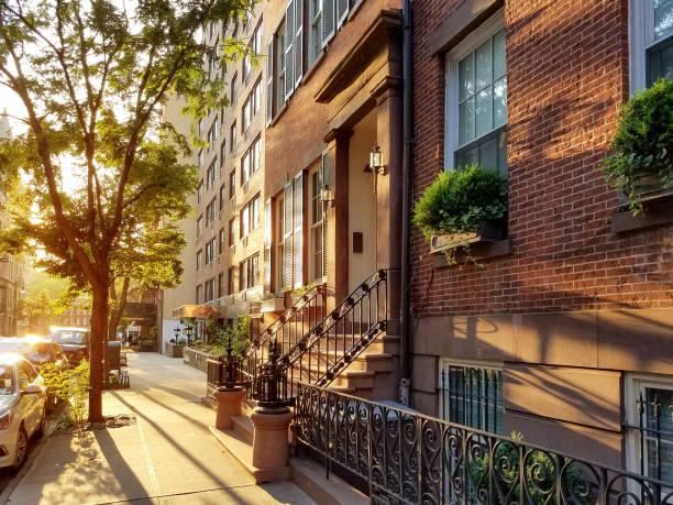Old brownstone buildings along a quiet neighborhood street in New York City stock photo