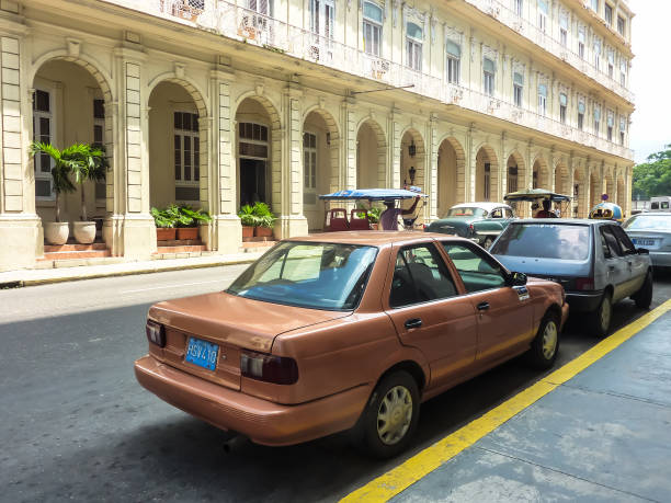 Old cars, standing near a footpath on the street of old Havana, Cuba stock photo