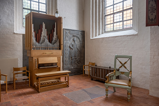 Old chair and modern organ in front of a old tombstone in Sankt Olai Kirke – Saint Olaf’s Church – is a Danish cathedral church in Helsingør also known as Elsinore in English. It has a history going back to around 1200, but the preset building is from 1559.