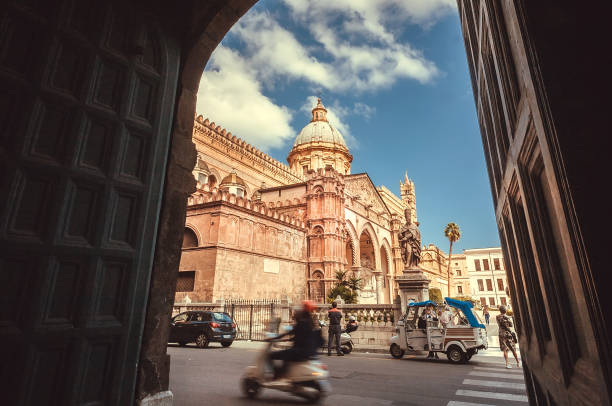 Old city gates, the 18th century catholic Palermo Cathedral and local transport driving around stock photo