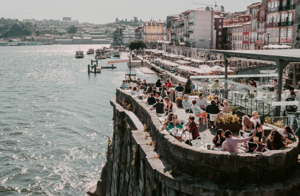 Old city houses over Douro river and many tourists having lunch at outdoor restaurant stock photo