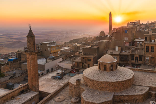 Old city of Mardin cityscape with roof of a Turkish hammam and minarets, Mardin, Turkey Mardin, Turkey - January 2020: Old city of Mardin cityscape with roof of a Turkish hammam and minarets during sunset mesopotamian stock pictures, royalty-free photos & images