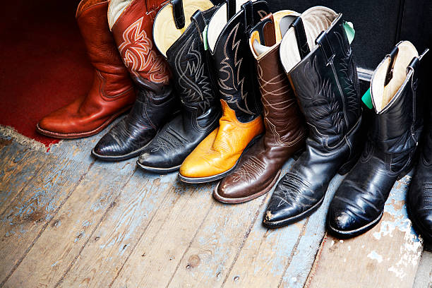 Old colored cowboy boots in a wooden floor stock photo