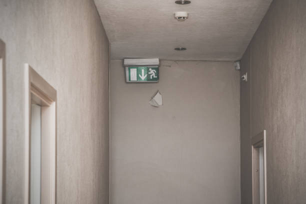 Old Corridor With Room Doors And Green Emergency Exit