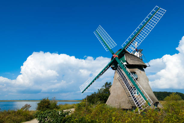 alte holländische stil windmühle in schöner landschaft in der nähe des baltischen meeres - schleswig holstein stock-fotos und bilder