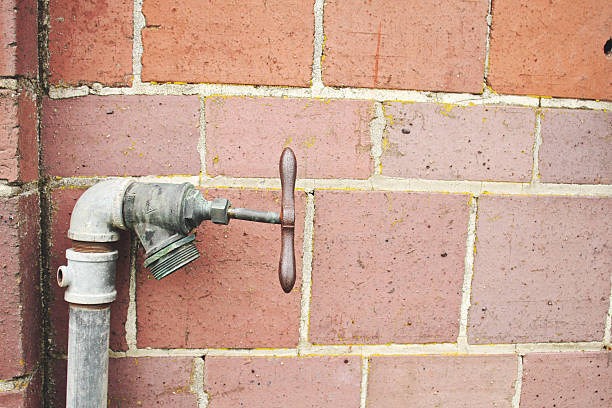 Old Fashioned Water Spigot and Brick Wall stock photo