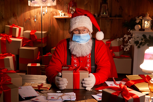 old funny bearded santa claus wearing face mask holding gift box for picture id1280356901?b=1&k=20&m=1280356901&s=170667a&w=0&h=jL6 dRUTscuQ2Ojh3 Merry Christmas 2021: Best wishes, images, messages, greetings to share with Your Friends and Family on December 25