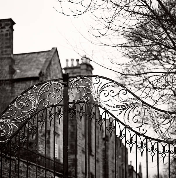 Old gate, Durham - Traditional Anglosaxon gate, closed, with mansion An old gate in Durham, England. Focus on the gate. Black and white film photography county durham england stock pictures, royalty-free photos & images