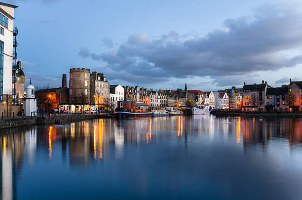 Old Harbour at Twilight and Reflection in Water Photo of Historic Leith Harbour in Edinburgh at Twilight. The Old Buildings than line the harbour are reflected in the calm water as well as the boats moored to the quay. edinburgh scotland stock pictures, royalty-free photos & images