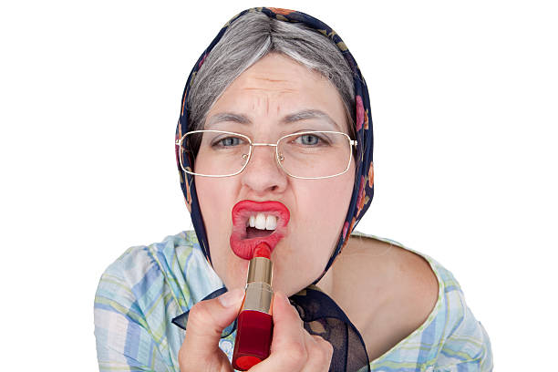 Old Lady Putting Lipstick On An old lady putting bright red lipstick on. ugly old women stock pictures, royalty-free photos & images