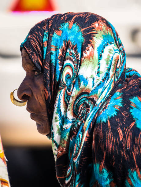 Old Local Woman in Colorful Scarf on the road to Massawa stock photo