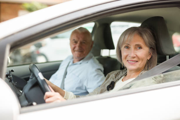 Old man and woman sitting in car stock photo