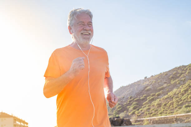 old man or senior running alone in a rural zone around the nature and houses - one mature male doing exercise and losing weight  fat man looks at the phone stock pictures, royalty-free photos & images