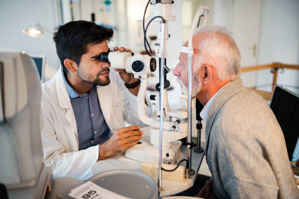 Old men having an eye exam at ophthalmologist's office. Senior men having her eyes checked at young male ophthalmologist. 50 59 years photos stock pictures, royalty-free photos & images