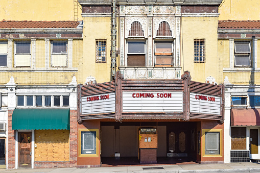 The facade of an old movie theater with Coming Soon on the marquee.