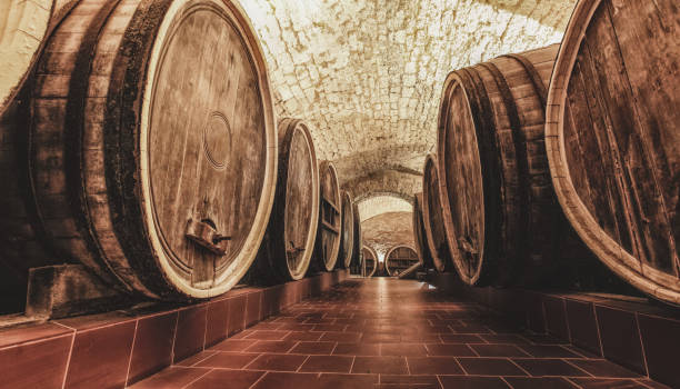 Old oak barrels in an ancient wine cellar. Century tradition of wine production stock photo